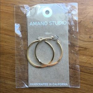 Gold hoop earrings by Amano Studio.